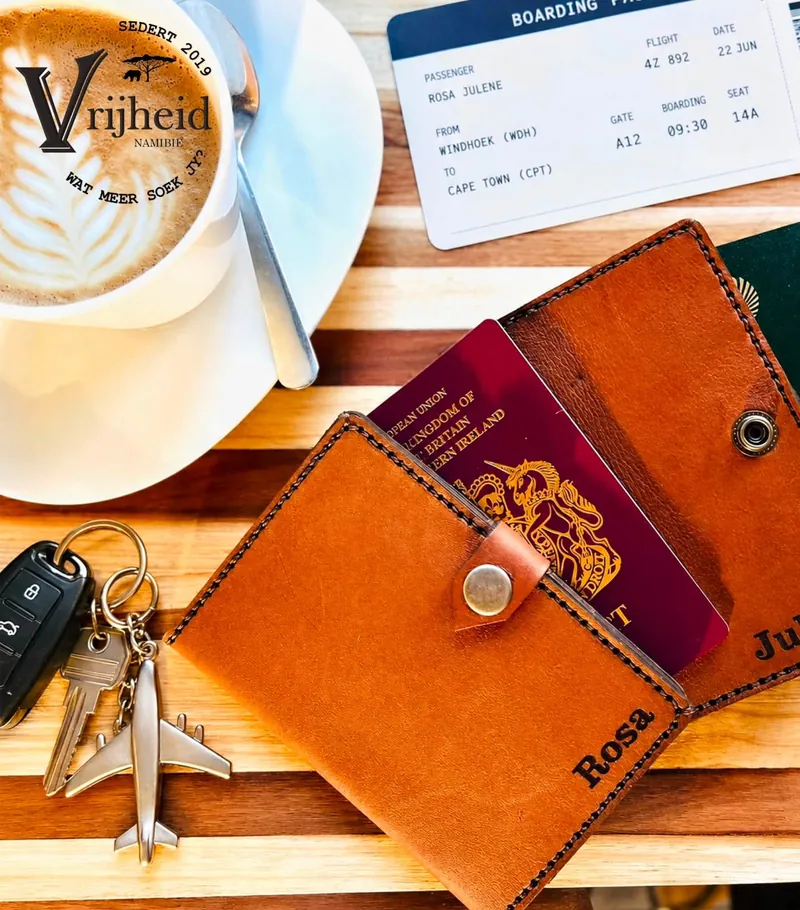 Engraved leather travel document cover with a passport, boarding pass and coffee